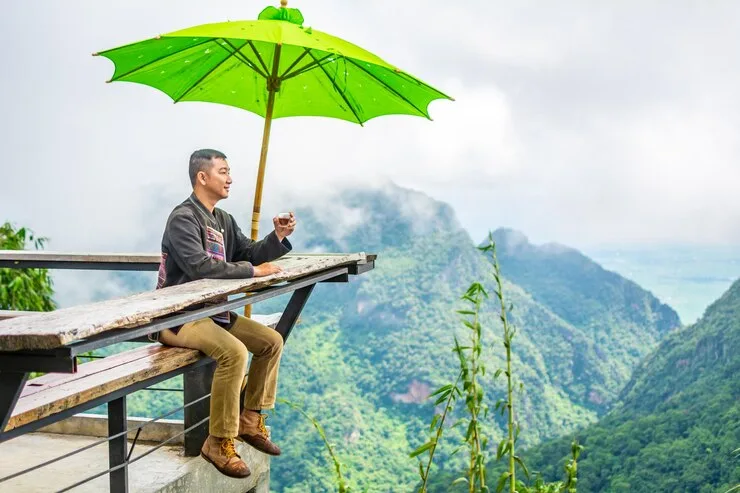 man holding cup while sitting umbrella rooftop 1048944 21665747
